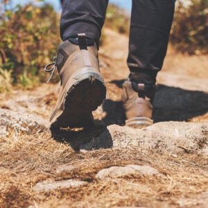 Closeup image of a woman hiking with trekking boots on the top of mountain
